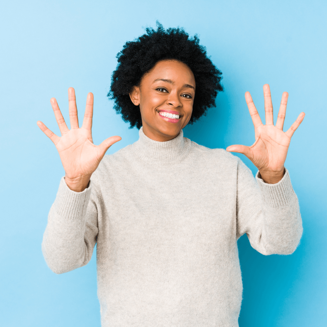 Eine Frau lächelt, während sie in einem Zahnarztstuhl sitzt.